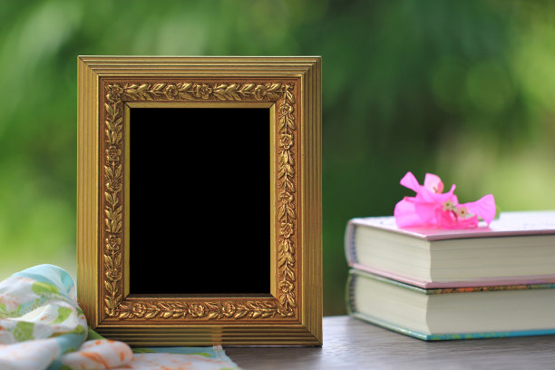 金画框，木桌上有书图片下载