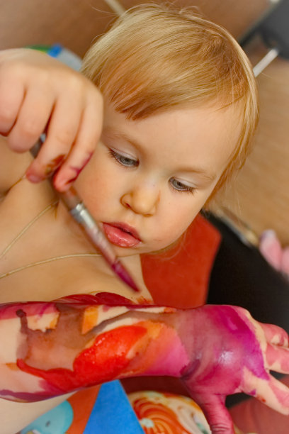 女孩用彩色画笔在自己身上画图片下载