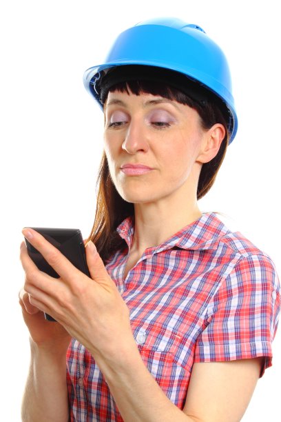 建筑工妇女在使用手机的保护头盔图片下载