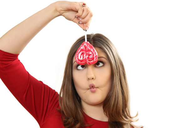 那个拿着棒棒糖的年轻女子一边扭动一边做鬼脸图片下载