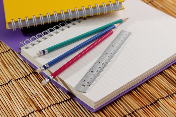 桌上放着文具笔记本和铅笔。图片下载