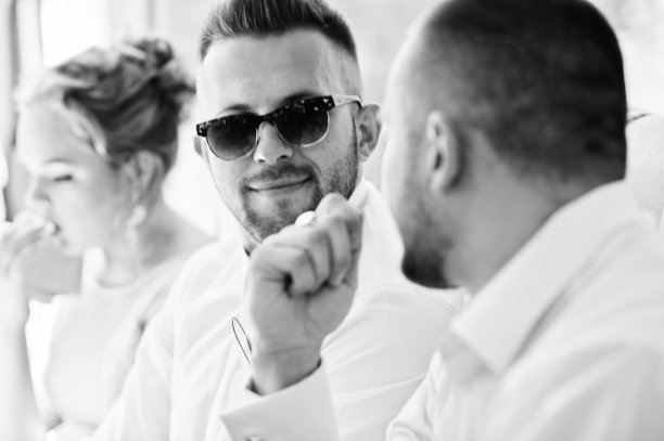 戴着墨镜的时尚男士和朋友聊天。在婚礼的伴郎。黑白照片图片下载