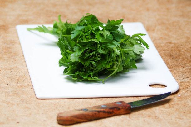 新鲜的草本绿色欧芹放在白板和刀上图片下载