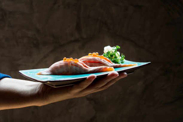 人们拿着三文鱼寿司图片下载