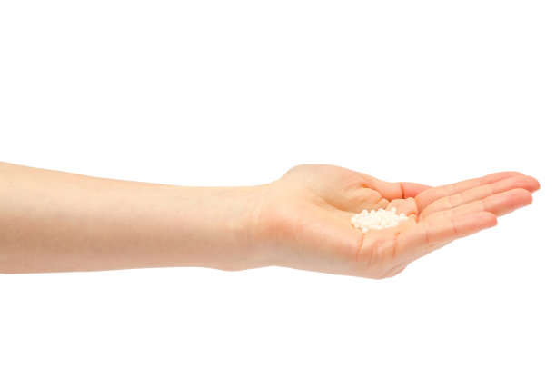 手持顺势疗法药物的年轻女孩的手。图片下载