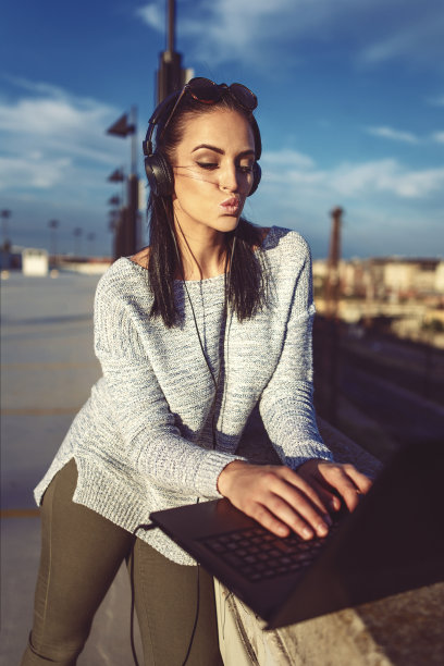 一个女人在户外用笔记本电脑接吻图片下载