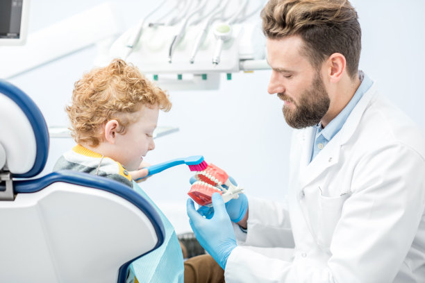 牙医和男孩在牙科诊所图片下载