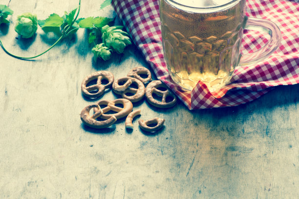 德国啤酒节背景：啤酒杯与椒盐卷饼图片下载