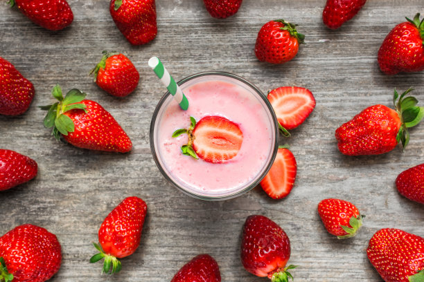 草莓冰沙或奶昔在一个玻璃杯与吸管图片下载