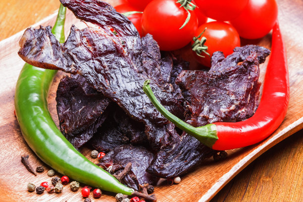 牛肉干，蔬菜和香料放在木托盘上素材图片