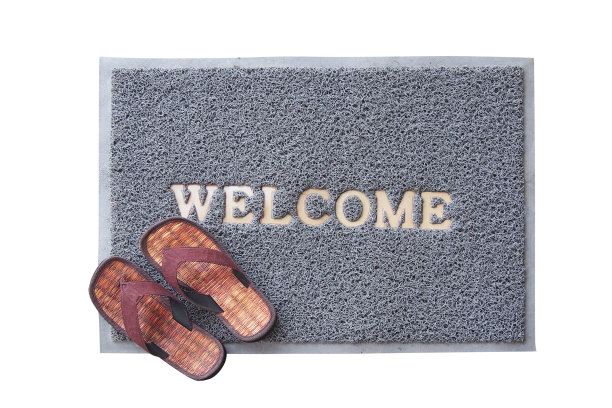 地板上放着棕色凉鞋的欢迎垫图片下载