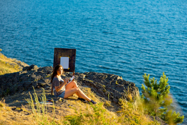 年轻的艺术家画了一幅日落时的海景画图片下载