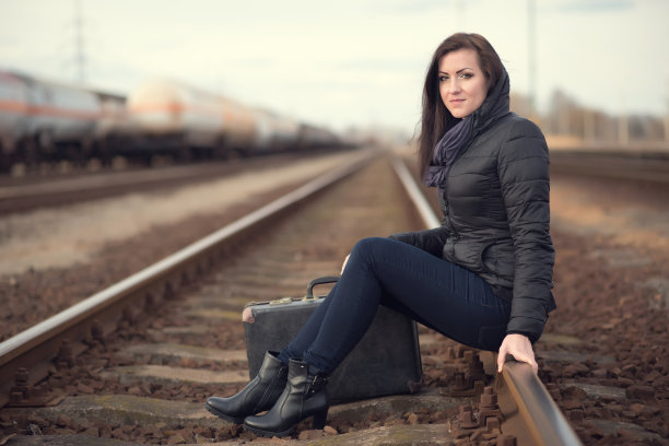 可悲的女人坐在火车轨道上图片下载