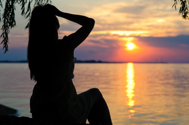 日落时一个穿着裙子的女孩的剪影图片下载