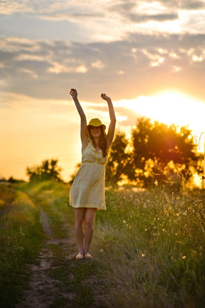 日落时分，穿着礼服戴着帽子的女孩图片下载