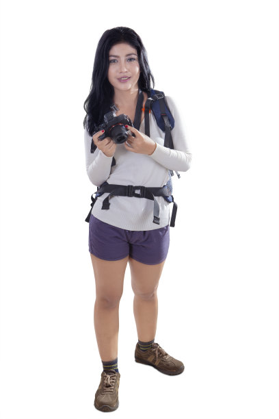 在摄影棚里拿着相机的女徒步旅行者图片下载