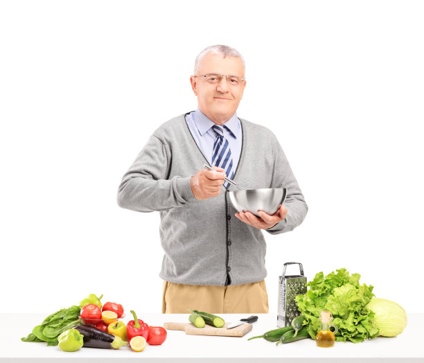 成熟微笑的绅士正在准备新鲜的沙拉图片下载