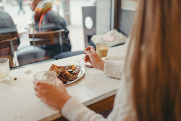长发女孩吃着松饼喝着咖啡图片下载