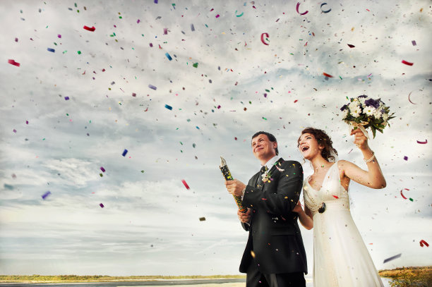 新婚夫妇燃放五彩纸屑烟花图片下载