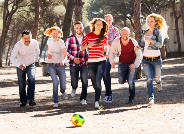 微笑的成年人在户外追逐球图片下载