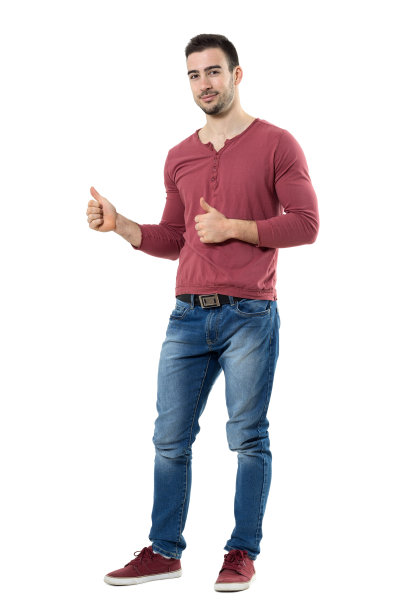 成功的年轻随意的男人显示大拇指看着相机。图片下载