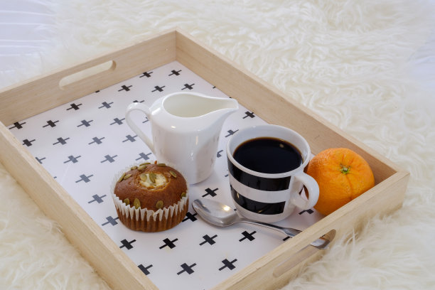 早餐放在床上托盘里，上面有咖啡、纸杯蛋糕和有机橙子图片下载