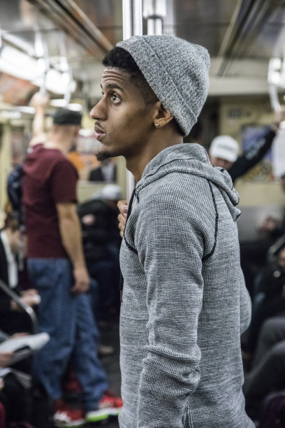 这是一幅20多岁的黑人年轻人乘坐纽约地铁的偷拍照片图片下载