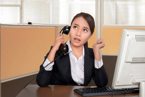 愉快的亚洲商务女性，一边坐着一边讲电话图片下载