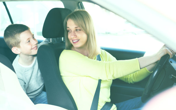 高兴的母亲和儿子开车在城市旅游期间图片下载