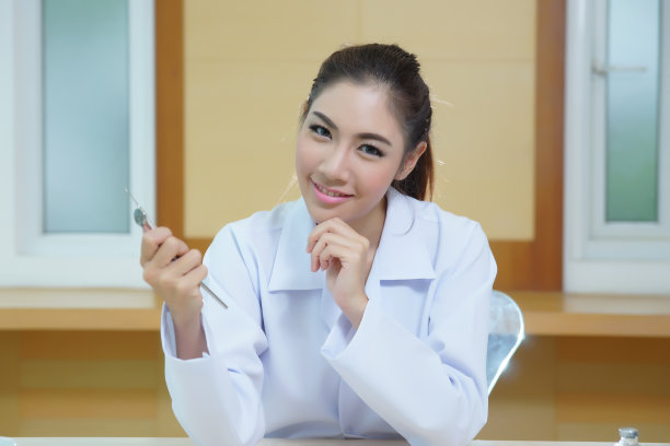 年轻漂亮的女牙医拿着牙科工具图片下载