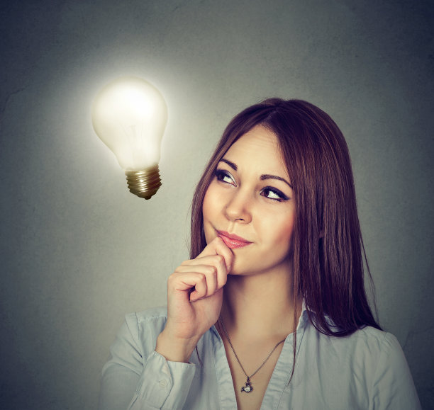 美丽快乐的女人抬头看着明亮的灯泡素材图片