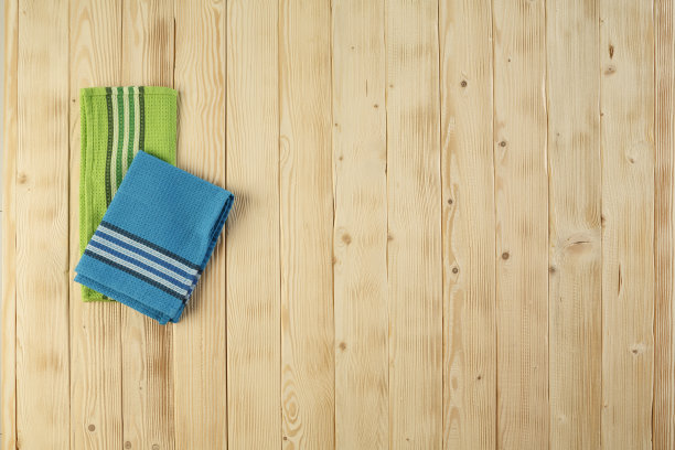 木制的野餐桌，上面铺着蓝色和绿色的抹布。图片下载