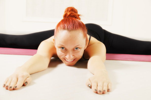 红头发的人微笑着在地板上伸直双腿图片下载