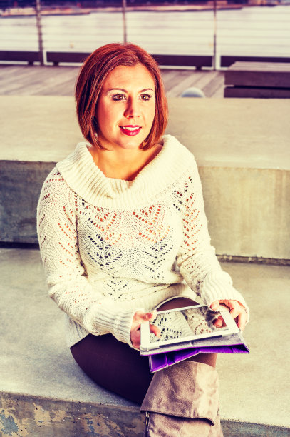 年轻的美国女人在外面读书图片下载