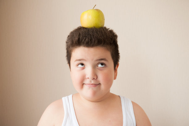 快乐的胖男孩，头上顶着个苹果图片下载