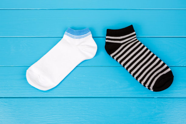 一双袜子躺在一个蓝色的木制背景。图片下载