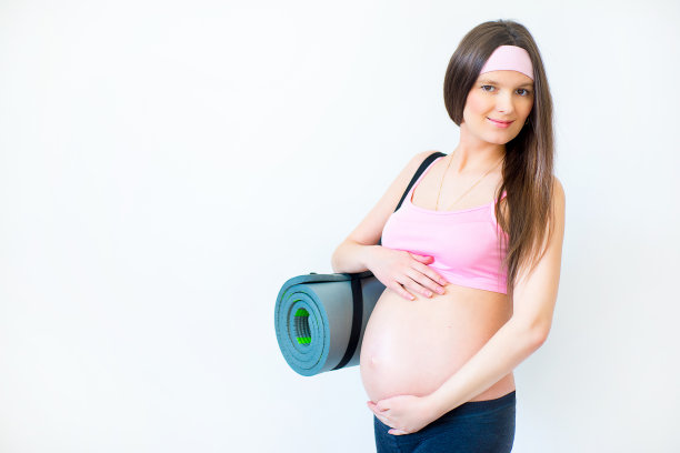 怀孕的女孩拿着健身垫图片下载