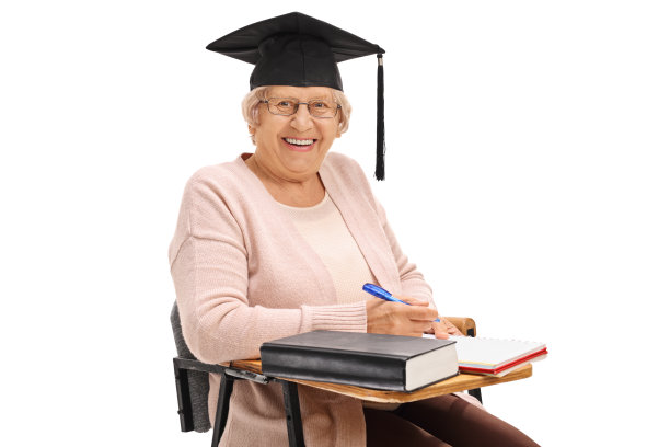 快乐的老奶奶戴着毕业帽坐在学校的椅子上图片下载