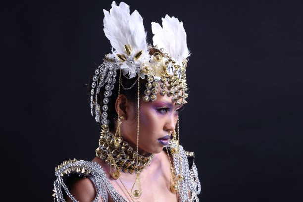 战士服装与白色羽毛帽子在美丽的花哨化妆女人，穗手腕禁令和链图片下载