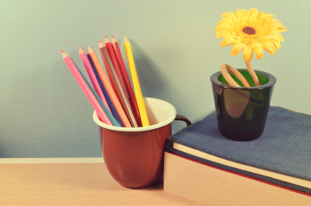 棕色的杯子和蜡笔在桌子上。图片下载