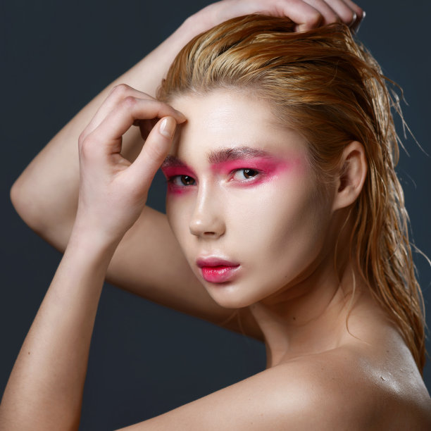 描绘年轻的金发女孩湿头发和粉红色的化妆图片下载