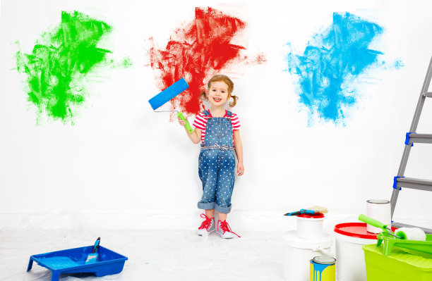 修复在公寓。快乐的小女孩刷墙图片下载