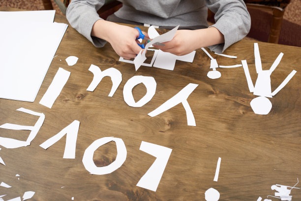 男孩做折纸-车和家庭，孩子，父母，我爱你的文字，顶视图上木背景图片下载