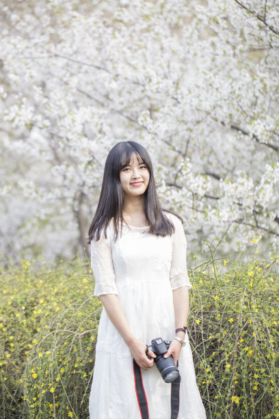 微笑，亚洲，户外，春天，十几岁的女孩，20-29岁，成年人，美丽的人，美丽，黑发，开朗，白日做梦，花，花坛，正式的花园，绿色，幸福，长发，看着相机，一个人，只有女人，人，马尾辫，肖像素材图片