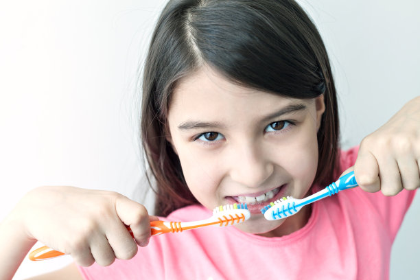 小女孩看着相机，微笑着刷牙图片下载