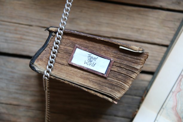 旅行世界标签和复古书在旧桌子上图片下载