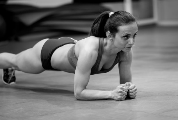 年轻女子在健身房伸展身体图片下载