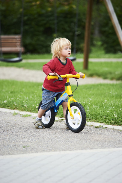 快乐的蹒跚学步的男孩骑自行车。喜欢骑自行车的孩子们。图片下载