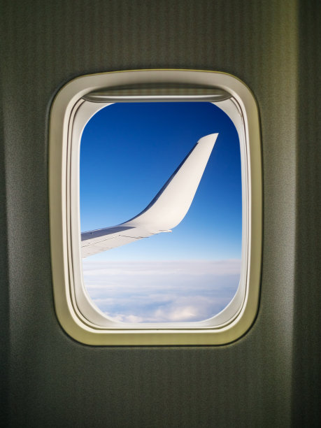 透过飞机窗口观看机翼和蓝天图片下载