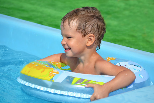 带着充气的小男孩在游泳池里漂浮图片下载